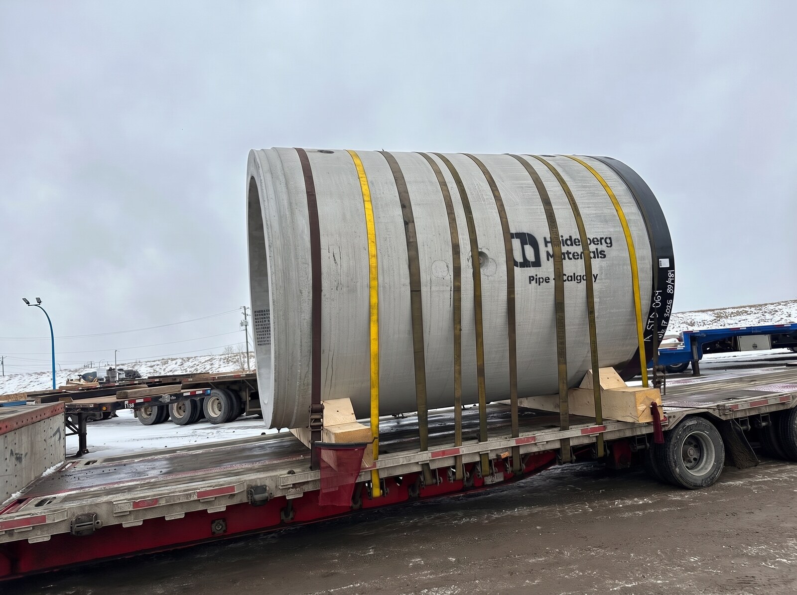 Chargement de conduites en béton préfabriqué sur lowboy